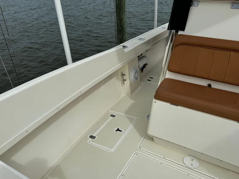 Slide: The Image of 2004 Intrepid 32 Cuddy boat interior with tan seating and storage compartments. - 20