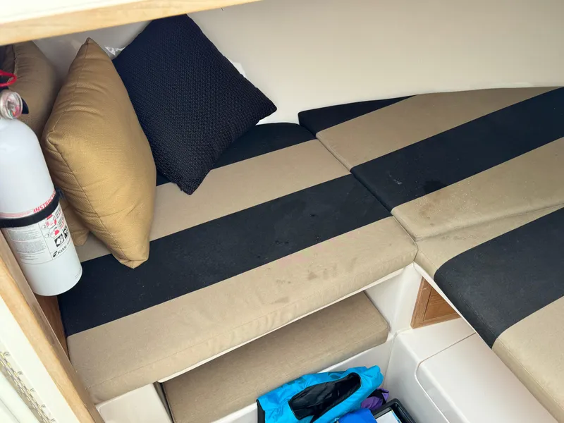 Slide: The Image of 2004 Intrepid 32 Cuddy cabin interior with striped cushions and pillows. - 24