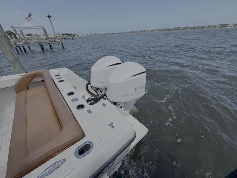 Slide: The Image of 2004 Intrepid 32 Cuddy boat with dual outboard motors on the water. - 7