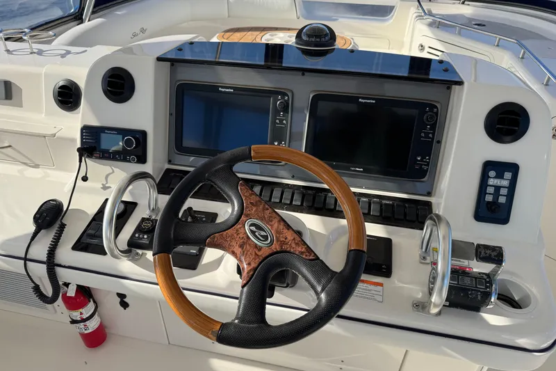 Slide: The Image of 2007 Sea Ray 58 Sedan Bridge helm with steering wheel and navigation controls. - 23