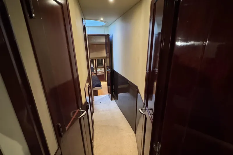 Slide: The Image of Hallway inside 2007 Sea Ray 58 Sedan Bridge yacht with wooden doors and carpeted floor. - 38