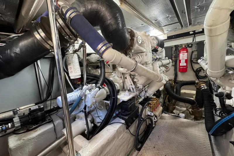 Slide: The Image of Engine room of 2007 Sea Ray 58 Sedan Bridge yacht, featuring complex machinery and fire extinguisher. - 56