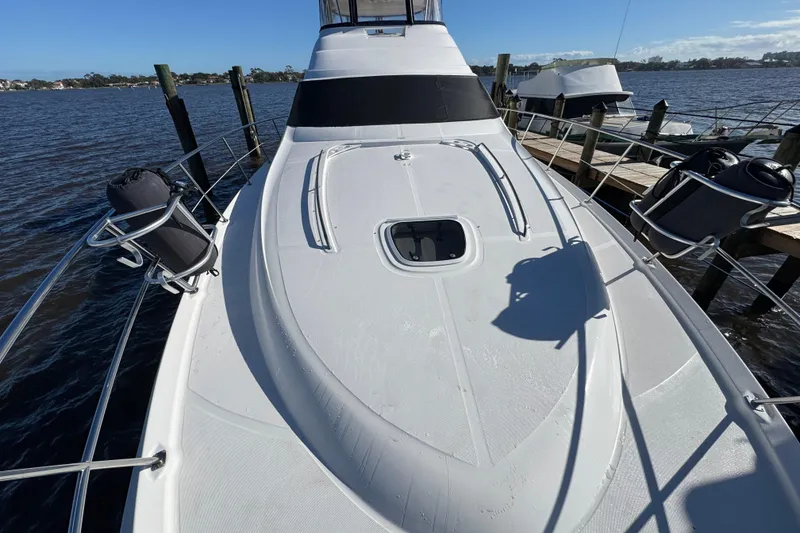 Slide: The Image of 2007 Sea Ray 58 Sedan Bridge yacht docked, showcasing sleek deck design and railing. - 6