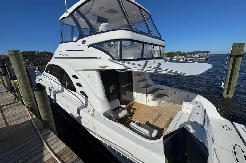 Slide: The Image of 2007 Sea Ray 58 Sedan Bridge yacht docked, showcasing sleek design and spacious deck. - 9