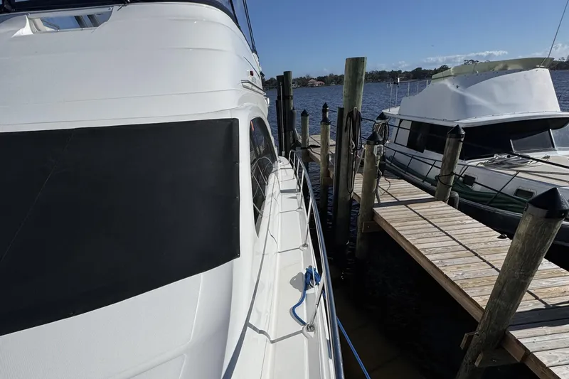 Slide: The Image of 2007 Sea Ray 58 Sedan Bridge yacht docked beside another boat on a sunny day. - 10