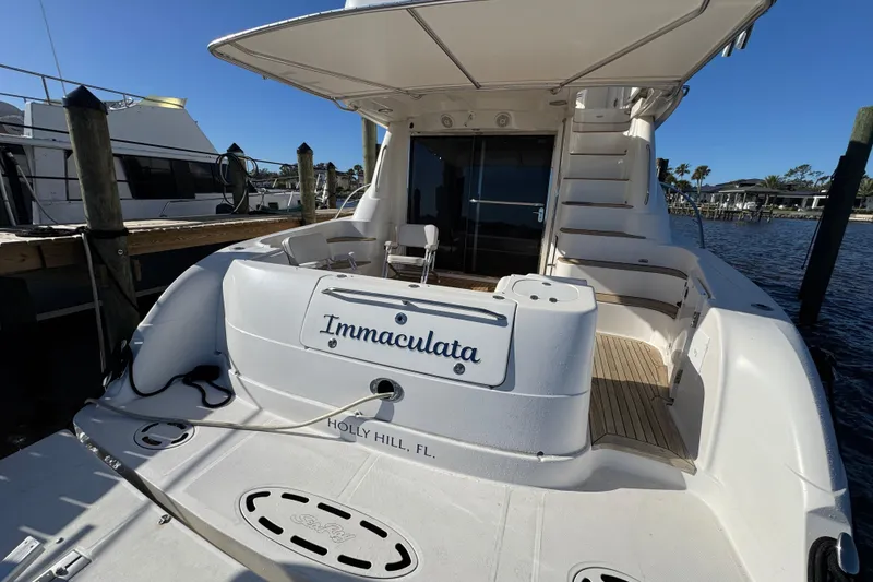 Slide: The Image of 2007 Sea Ray 58 Sedan Bridge yacht docked, rear view with "Immaculata" nameplate. - 11
