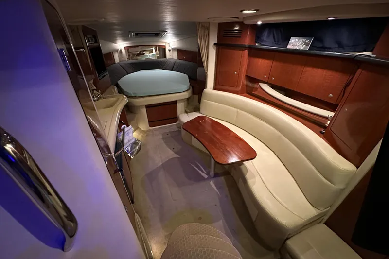 Slide: The Image of 2005 Sea Ray 320 Sundancer cabin interior with seating, table, and bed. - 12