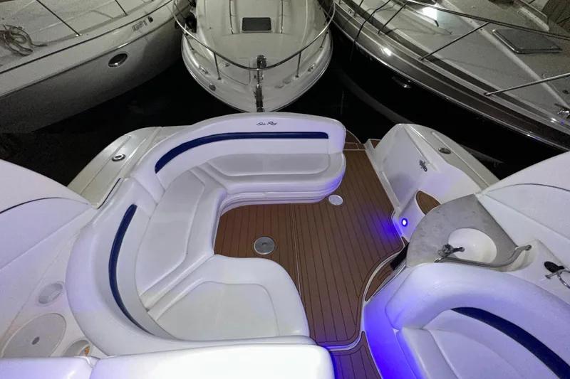 Slide: The Image of 2005 Sea Ray 320 Sundancer boat interior with white seating and wood flooring. - 7
