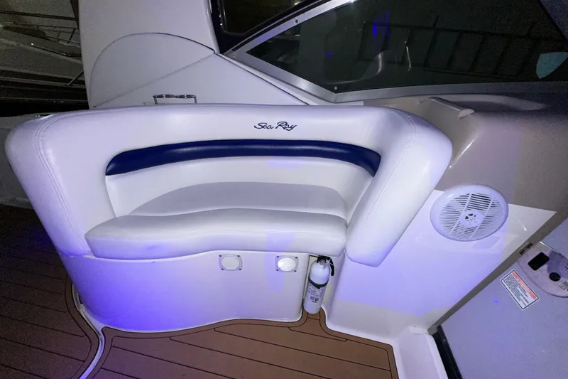 Slide: The Image of White and blue seating on 2005 Sea Ray 320 Sundancer boat, featuring sleek design and speaker. - 9