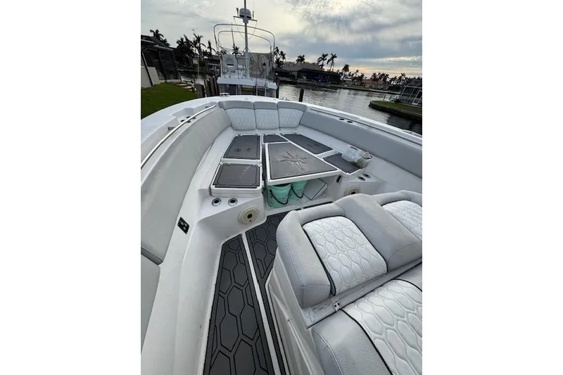 Slide: The Image of 2021 Sea Fox 368 Commander boat interior with cushioned seating and deck, docked by water. - 6