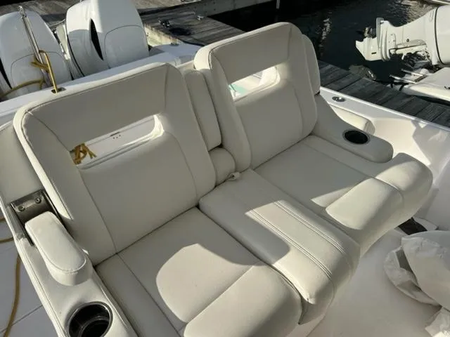 Slide: The Image of 2018 Intrepid 375 Walkaround boat with white cushioned seating and cup holders. - 18
