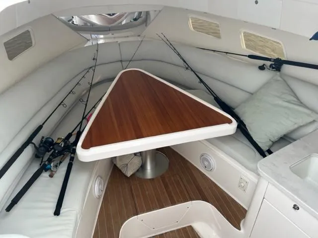 Slide: The Image of 2018 Intrepid 375 Walkaround cabin interior with fishing rods and triangular table. - 19