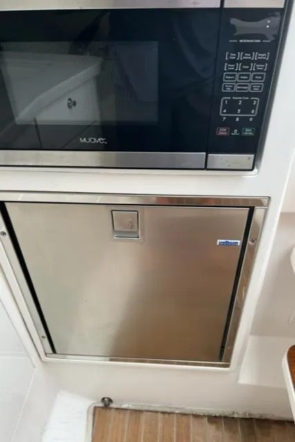 Slide: The Image of 2018 Intrepid 375 Walkaround kitchen with microwave and stainless steel fridge. - 27
