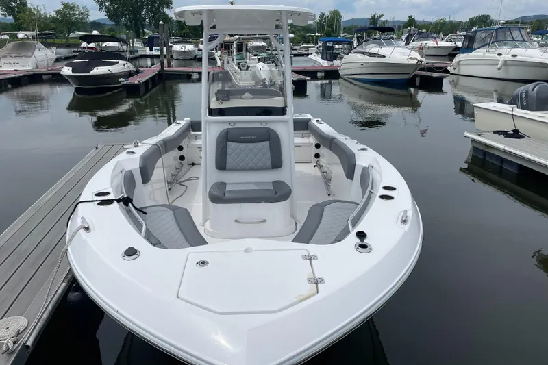 Slide: The Image of 2024 NauticStar 222L Offshore boat docked at marina, featuring sleek design and spacious seating. - 2