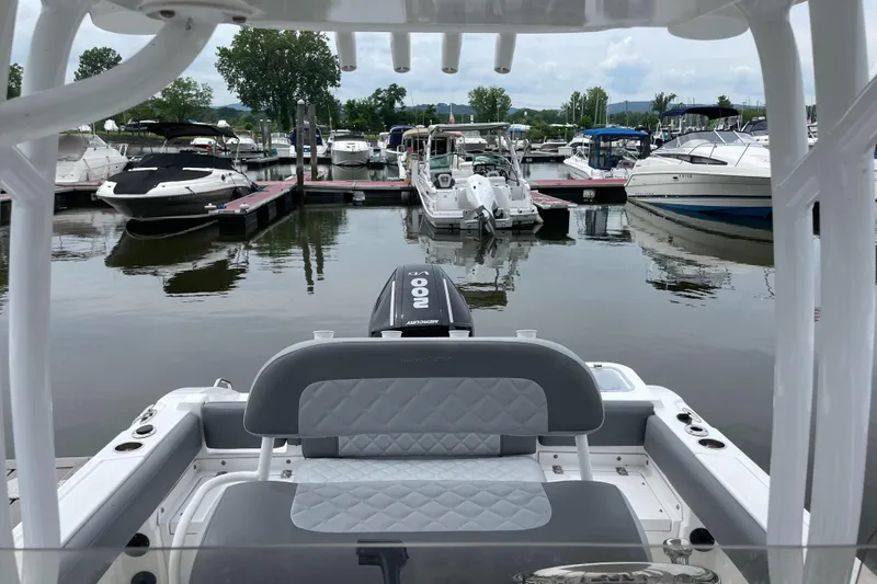 Slide: The Image of 2024 NauticStar 222L Offshore boat docked at a marina with other boats. - 5