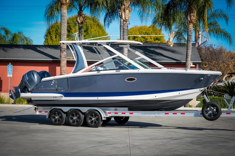 The Image of 2021 Chaparral 280 OSX boat on trailer, parked outdoors with palm trees in background. - 1