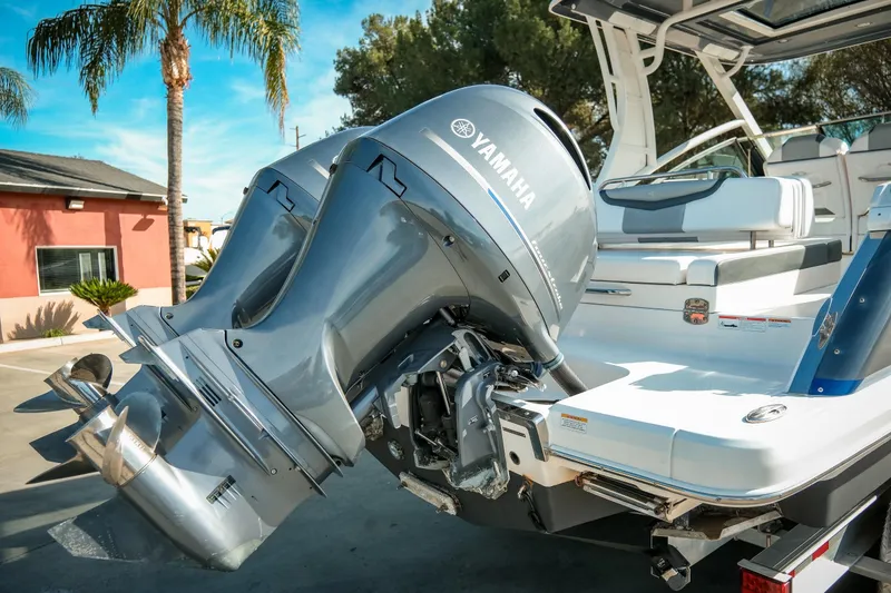 Slide: The Image of 2021 Chaparral 280 OSX boat with Yamaha outboard engines, docked under clear skies. - 9