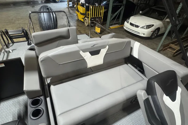 Slide: The Image of 2026 Evotti 521CS boat interior with gray seating and cup holders in a warehouse. - 13