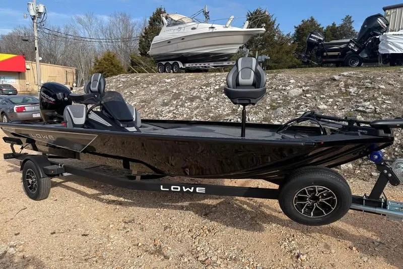 Slide: The Image of 2026 Lowe Stinger 195 Bass boat on trailer, parked outdoors. - 1