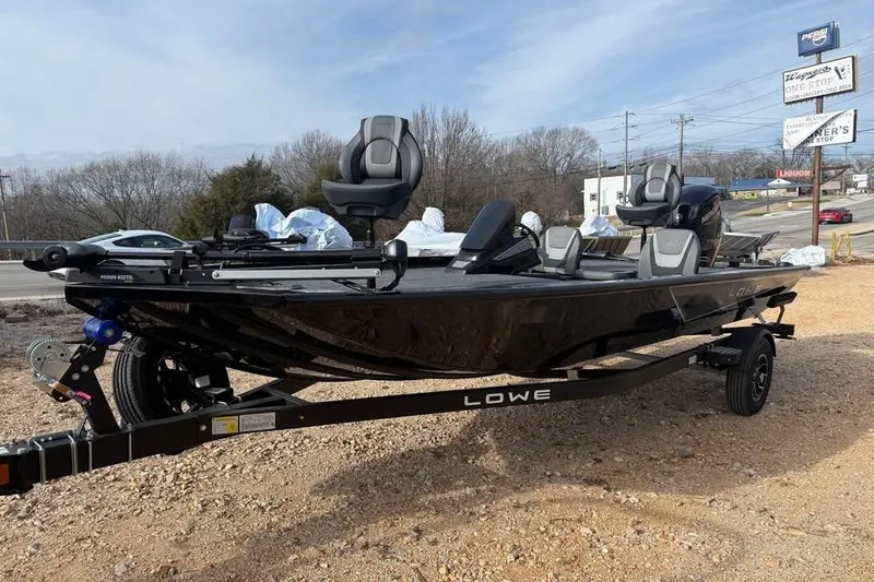 Slide: The Image of 2026 Lowe Stinger 195 Bass boat on trailer, parked outdoors, under clear sky. - 3