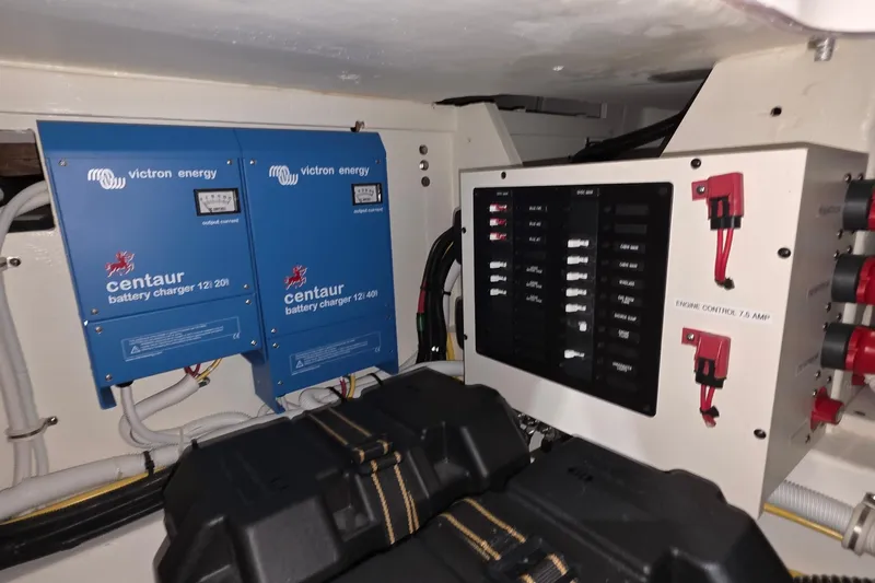 Slide: The Image of Electrical control panel of 2023 Tiara Sport 34LX boat, featuring AC and DC systems. - 52