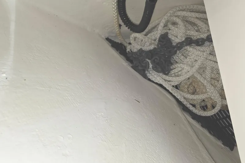Slide: The Image of Coiled ropes and chains in a storage compartment of a 2023 Tiara Sport 34LX boat. - 63
