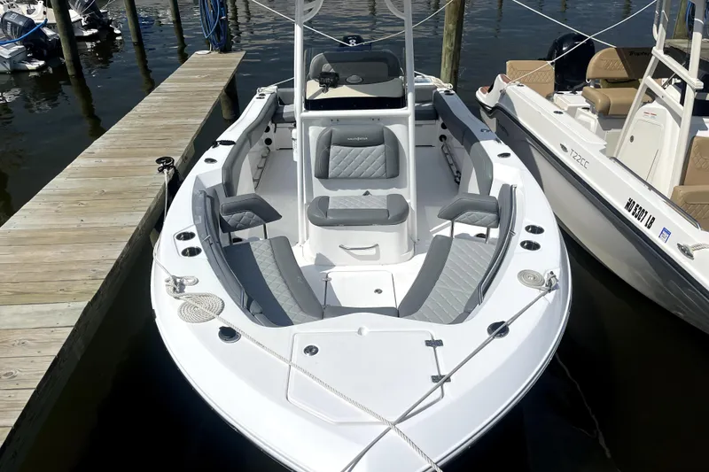 Slide: The Image of 2024 NauticStar 222L Offshore boat docked, featuring sleek design and comfortable seating. - 2