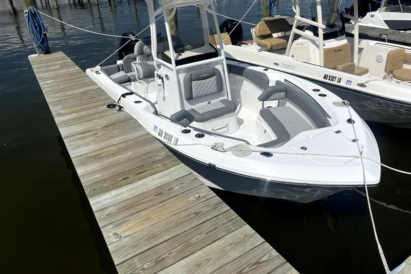 Slide: The Image of 2024 NauticStar 222L Offshore boat docked, featuring sleek design and comfortable seating. - 3