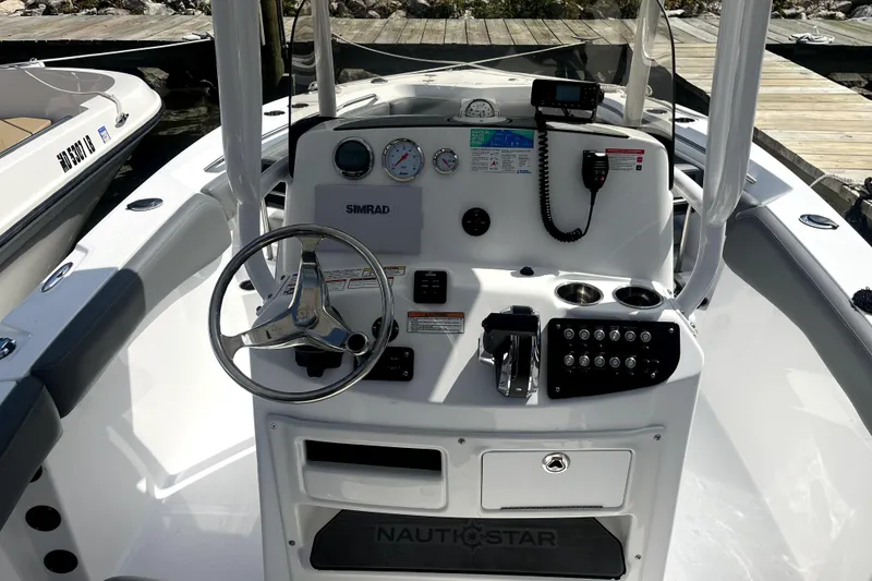 Slide: The Image of 2024 NauticStar 222L Offshore boat dashboard with steering wheel and controls. - 4