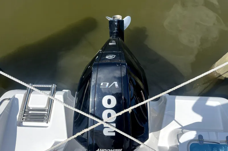 Slide: The Image of 2024 NauticStar 222L Offshore boat with powerful outboard motor, docked on calm water. - 8