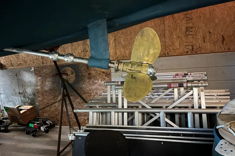 Slide: The Image of Propeller of 2001 Tartan 3700 Sloop in a workshop with ladders and tools. - 16