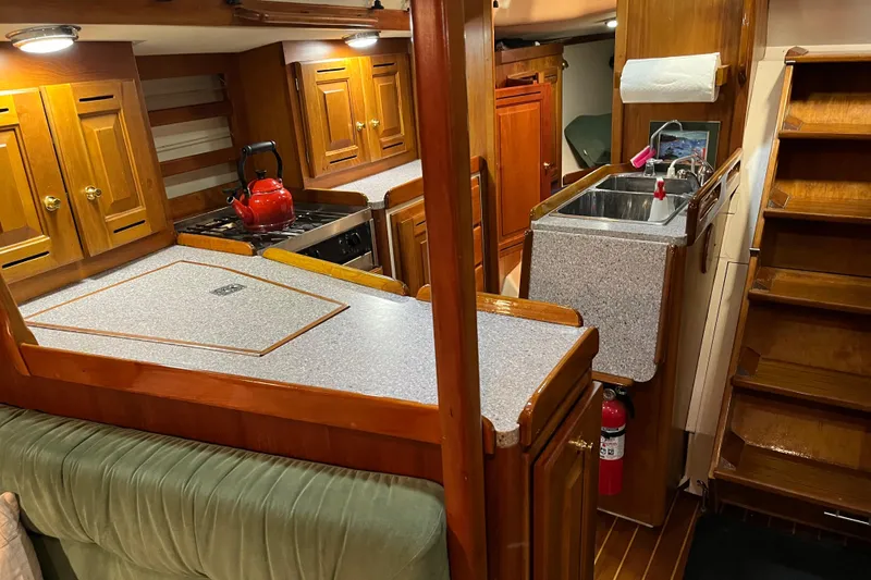 Slide: The Image of Interior of 2001 Tartan 3700 Sloop with wooden cabinetry and compact kitchen area. - 4