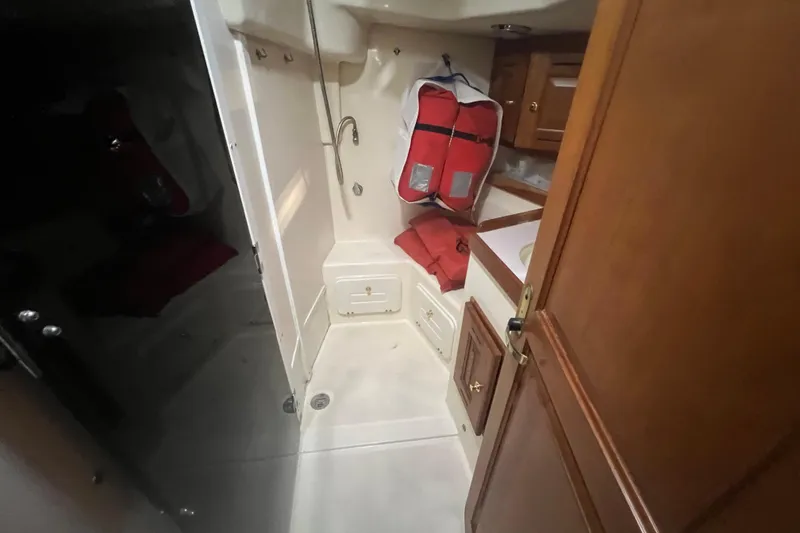 Slide: The Image of Interior of 2001 Tartan 3700 Sloop with wooden cabinets and life jackets. - 5