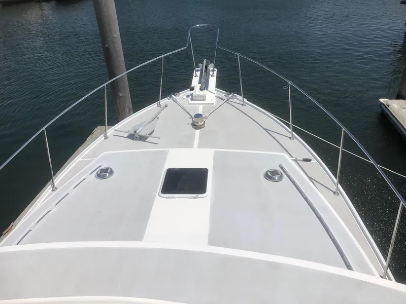 Slide: The Image of 2003 Wesmac Flybridge boat deck with railing, docked on calm water. - 10