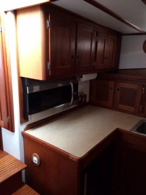 Slide: The Image of 2003 Wesmac Flybridge kitchen with wooden cabinets and countertop. - 12
