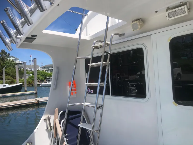 Slide: The Image of 2003 Wesmac Flybridge boat with ladder and docked at marina. - 14