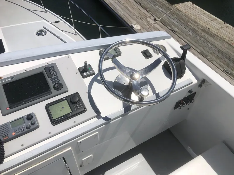 Slide: The Image of 2003 Wesmac Flybridge helm with steering wheel and navigation controls. - 15