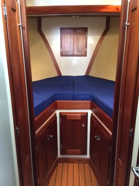Slide: The Image of 2003 Wesmac Flybridge cabin interior with wood paneling and blue cushions. - 17