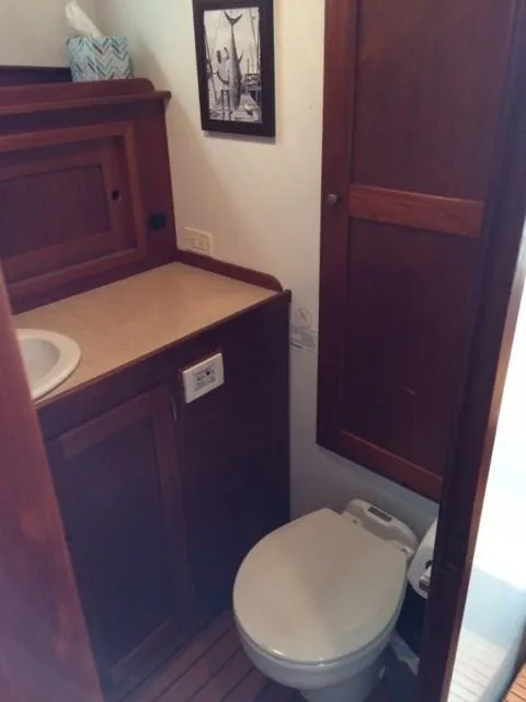 Slide: The Image of 2003 Wesmac Flybridge bathroom with wooden cabinets and compact toilet. - 18