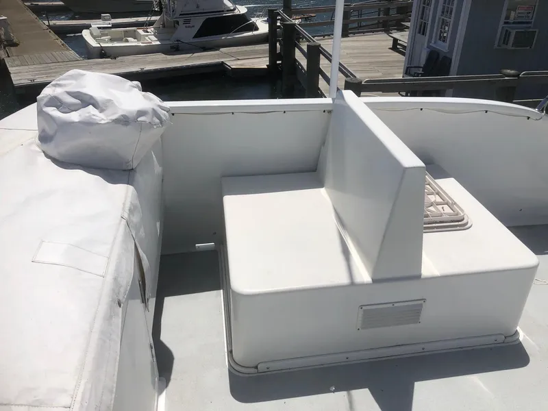 Slide: The Image of 2003 Wesmac Flybridge boat with white seating area at the dock. - 19