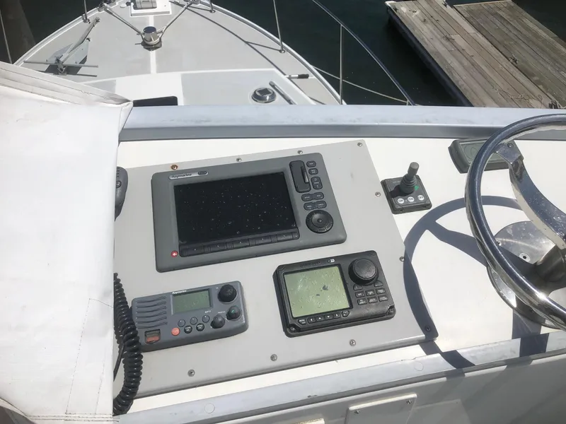 Slide: The Image of 2003 Wesmac Flybridge boat dashboard with navigation equipment and steering wheel. - 22