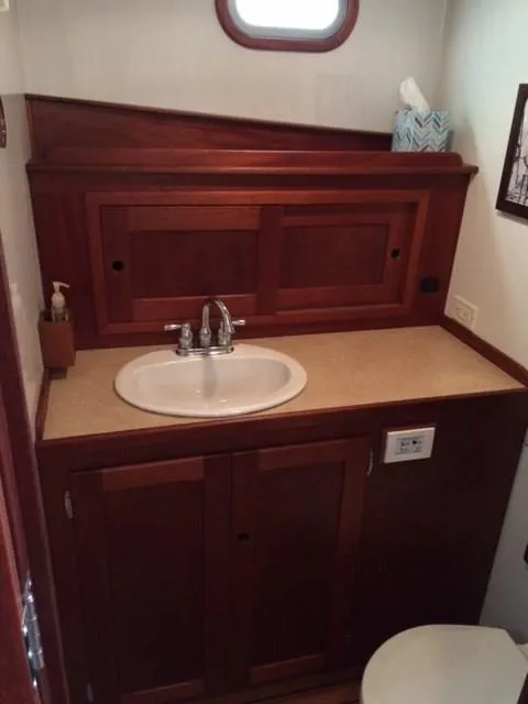 Slide: The Image of 2003 Wesmac Flybridge bathroom with wooden cabinetry and sink. - 23