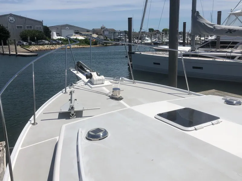 Slide: The Image of 2003 Wesmac Flybridge boat docked in a marina, showcasing spacious deck and sleek design. - 26