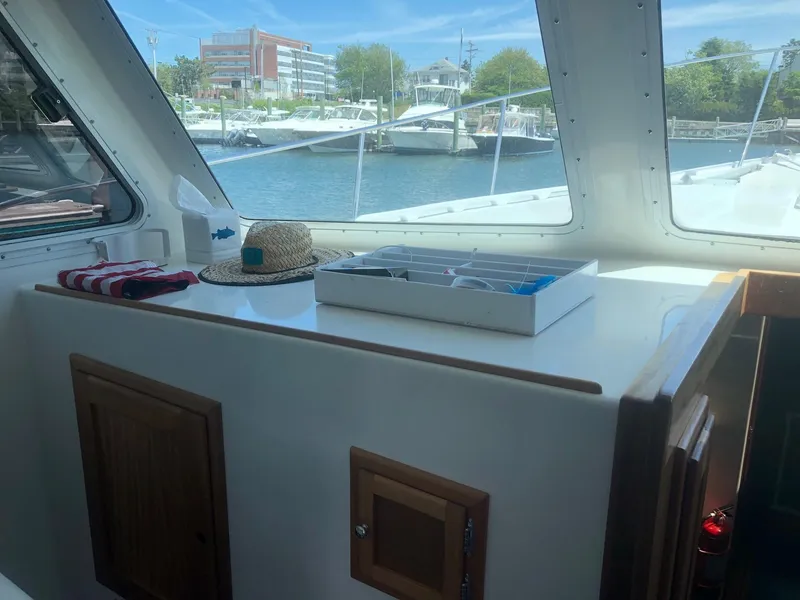 Slide: The Image of Interior view of 2003 Wesmac Flybridge boat with hat and box on counter. - 28