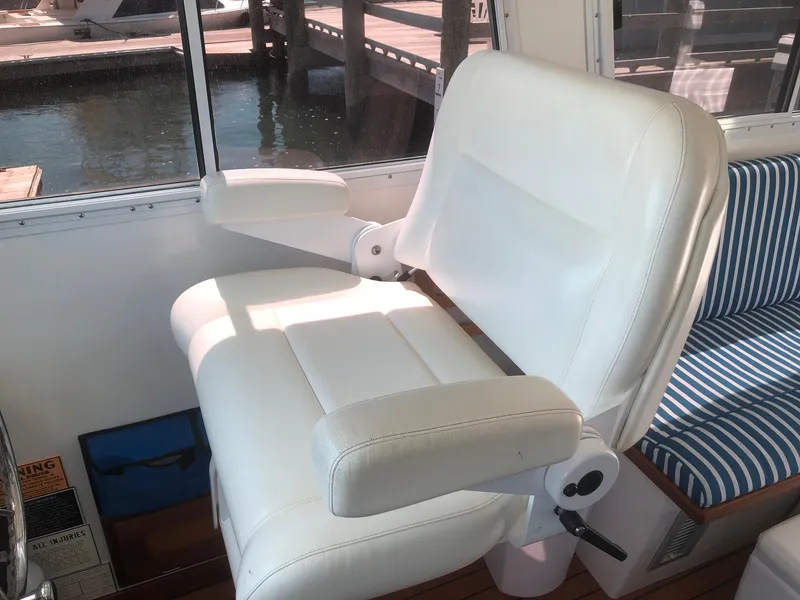 Slide: The Image of White captain's chair on 2003 Wesmac Flybridge boat, near window with water view. - 29