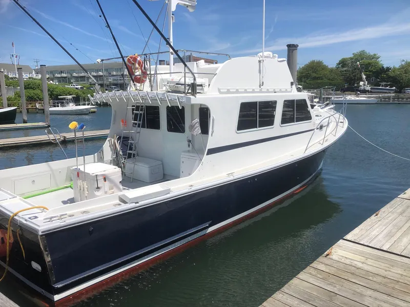 Slide: The Image of 2003 Wesmac Flybridge boat docked in a marina under clear skies. - 3