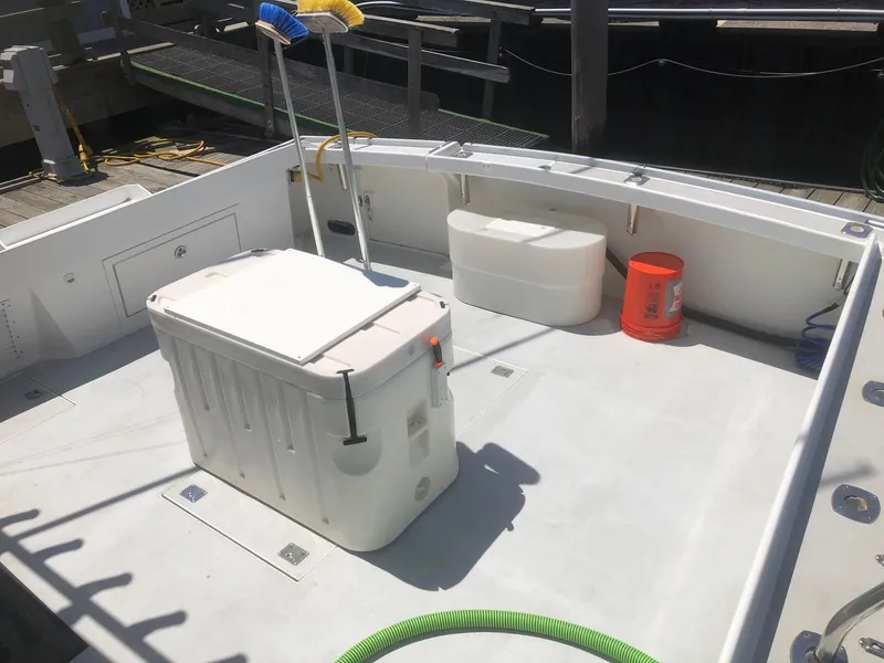 Slide: The Image of 2003 Wesmac Flybridge boat deck with storage, bucket, and cleaning tools. - 36