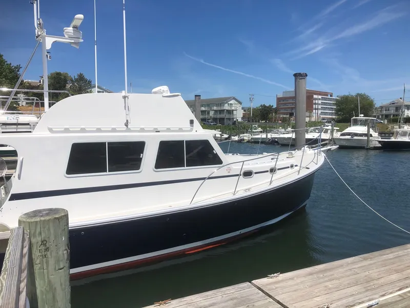Slide: The Image of 2003 Wesmac Flybridge boat docked in a marina under clear blue skies. - 4
