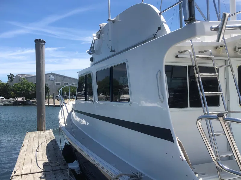 Slide: The Image of 2003 Wesmac Flybridge boat docked at marina under clear blue sky. - 8