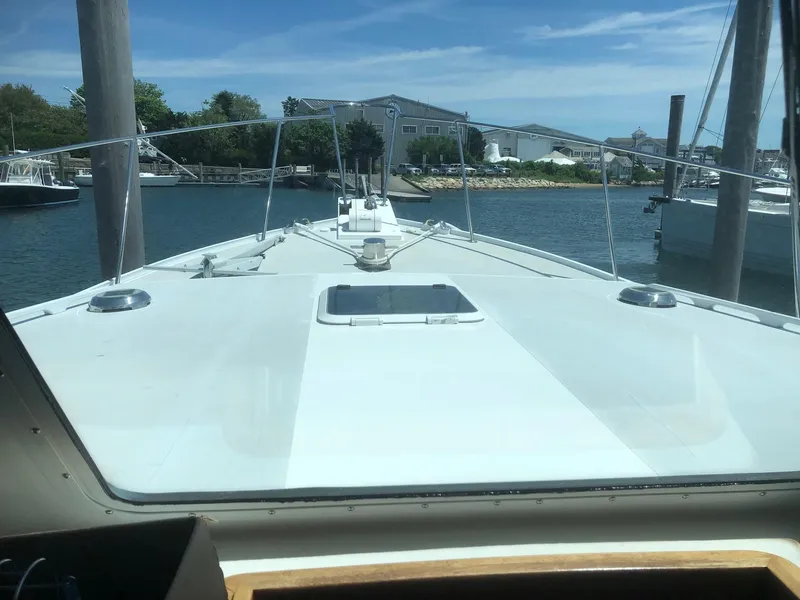Slide: The Image of 2003 Wesmac Flybridge boat docked in a marina under clear skies. - 9